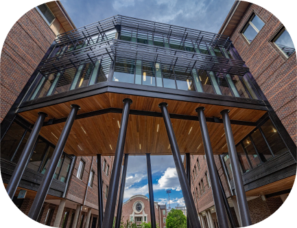 A modern university building at University of Denver with a glass facade and architectural pillars.